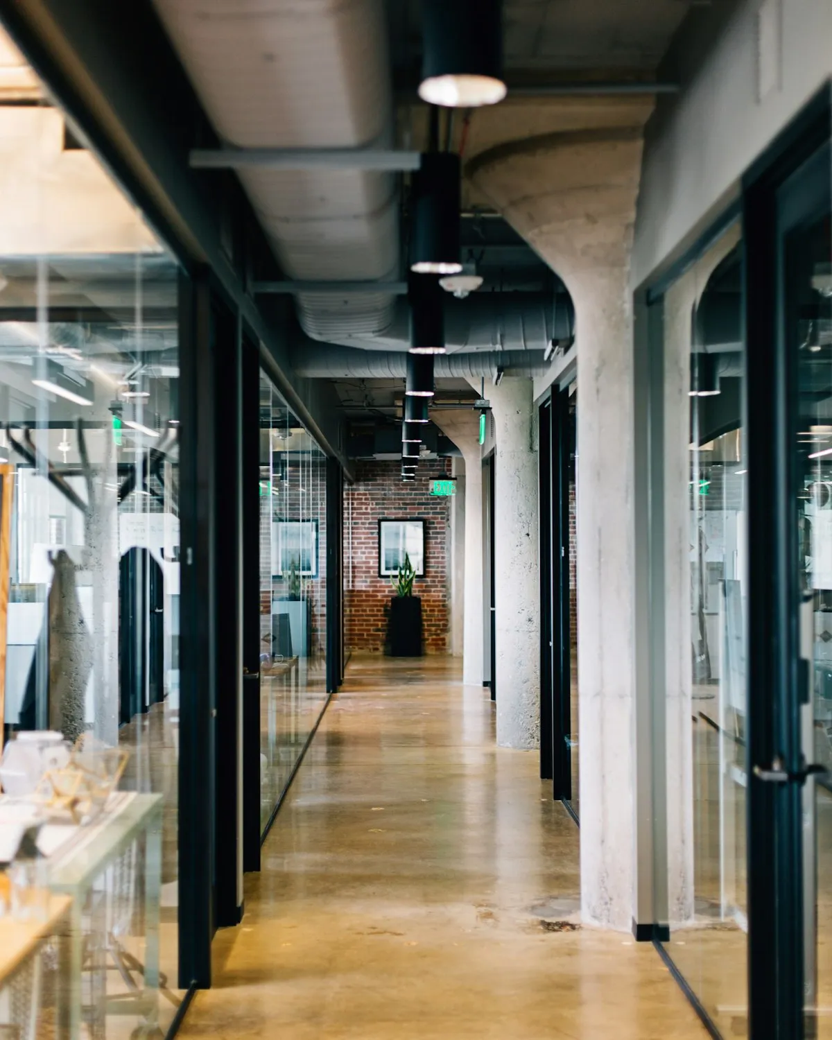 Office corridor with glass walls and concrete columns